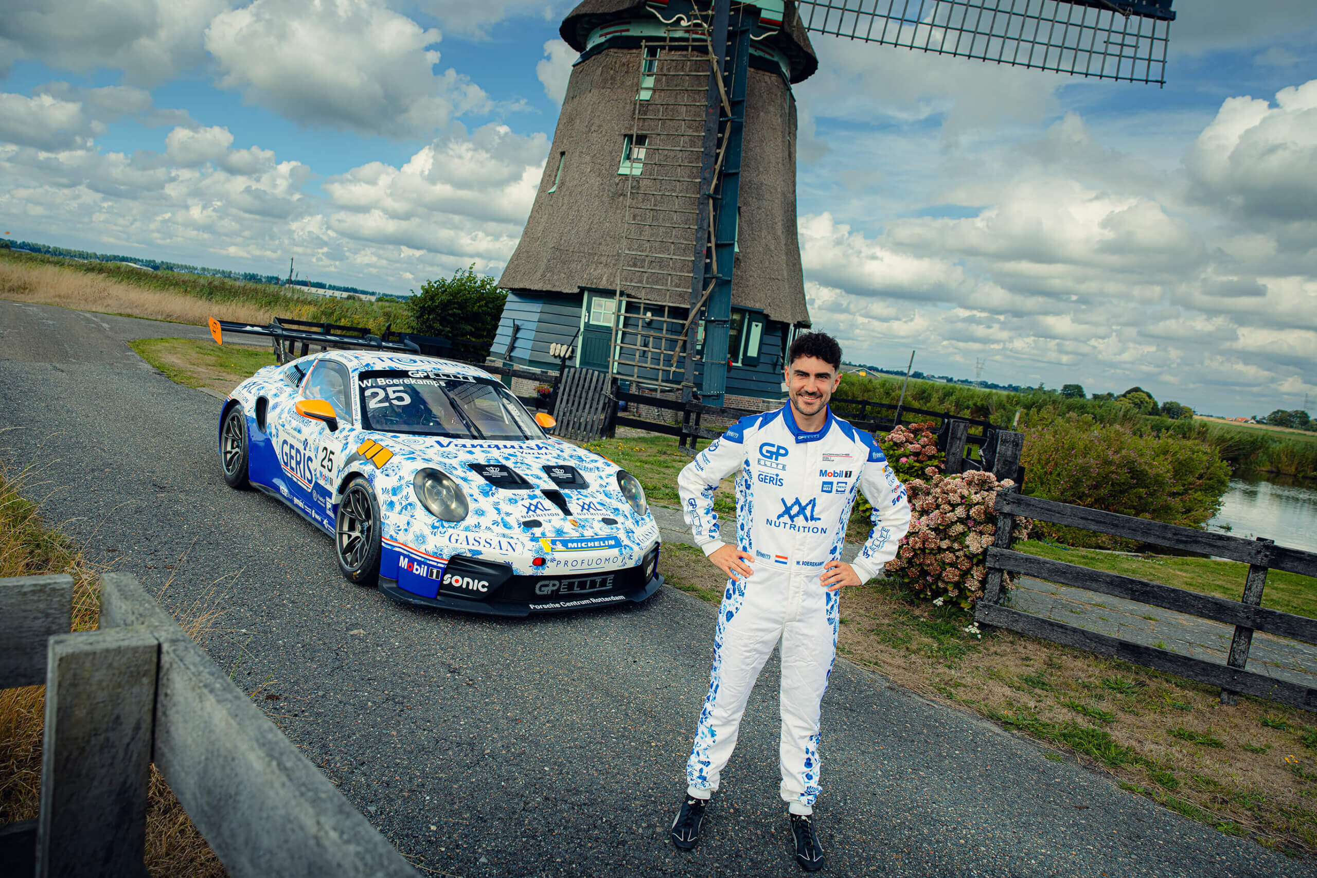 Porsche-raceauto van GP Elite in Delfts Blauwe livery bij een molen