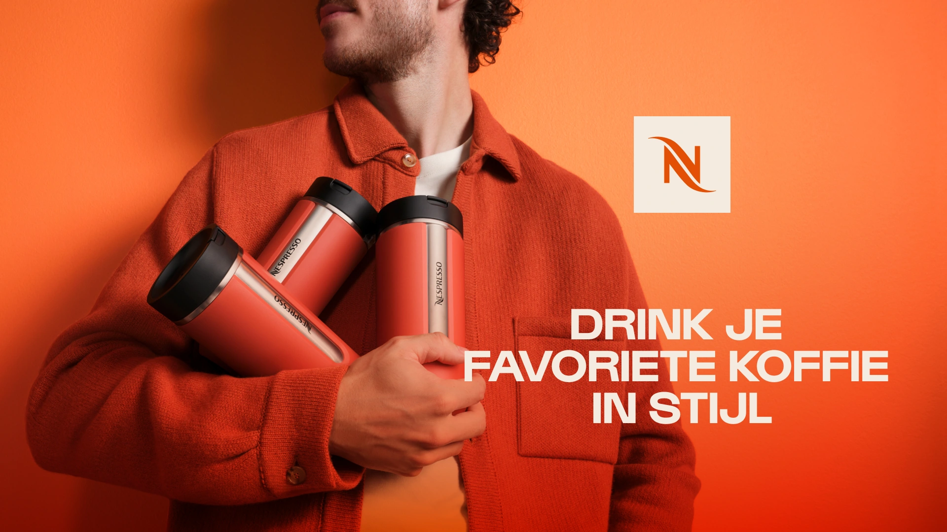 Nespresso-campagnebeeld met oranje achtergrond, koffiebekers en de tekst Drink je favoriete koffie in stijl