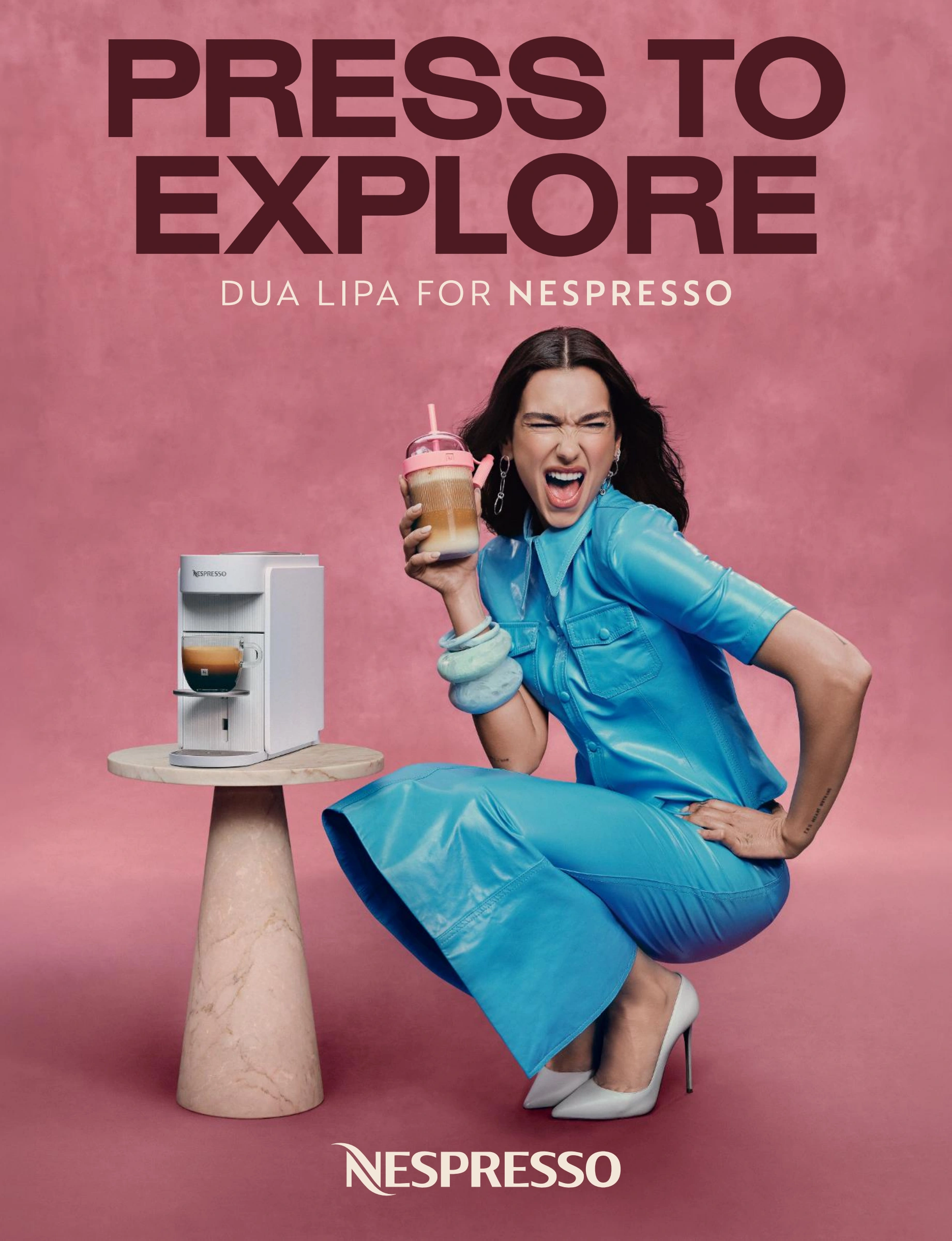 Nespresso-magazineadvertentie met de tekst Press to explore en een koffiepresentatie met Dua Lipa